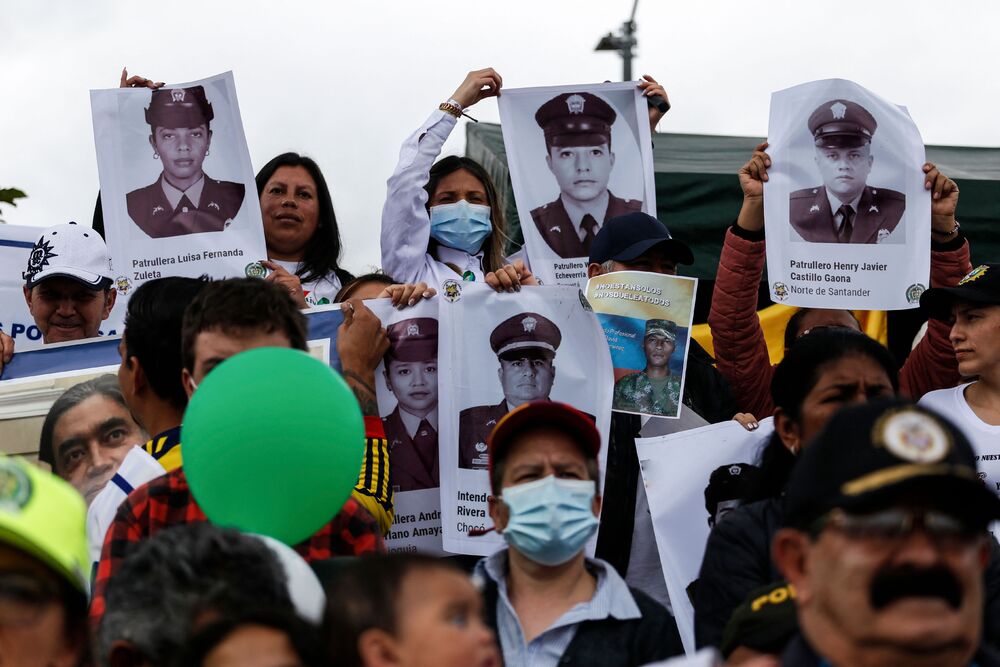 Supporters of Colombian outgoing President Ivan Duque show a banner during a demonstration in support of the National police rally against killings by irregular police forces, in Bogota. (AFP) Supporters of Colombian outgoing President Ivan Duque show a banner during a demonstration in support of the National police rally against killings by irregular police forces, in Bogota. (AFP)