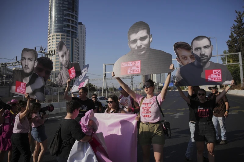 Demonstrators block a road during a protest demanding the immediate release of hostages held by Hamas and calling for the Israeli government to reverse its decision to take over Gaza City and other areas in the Gaza Strip, in Tel Aviv, Israel, Tuesday, Aug. 19, 2025. (AP Photo/Ohad Zwigenberg)