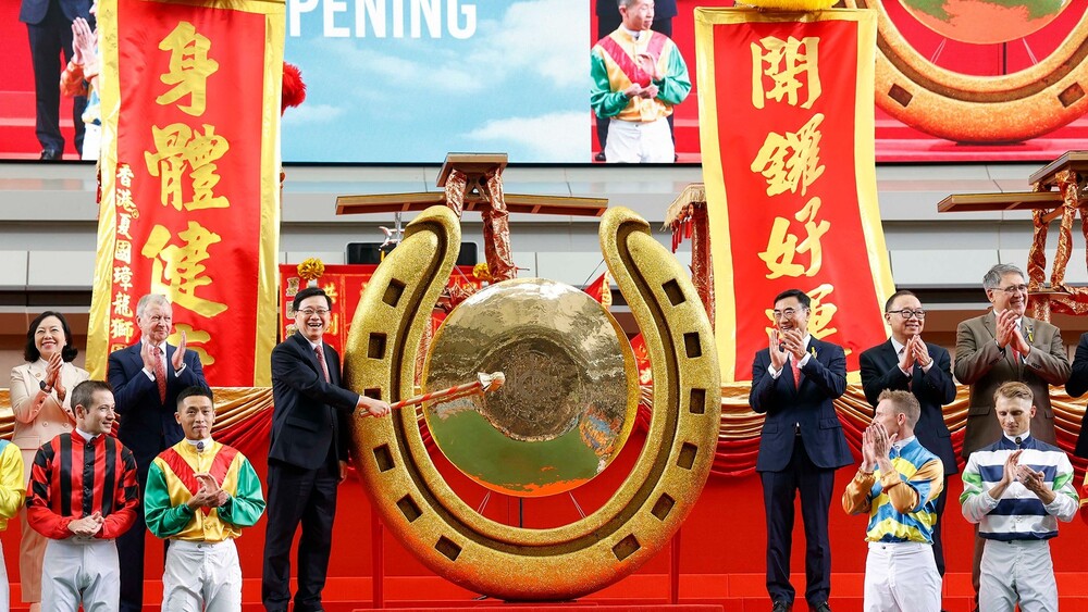 HKSAR Chief Executive John Lee (3rd left, back row) strikes the ceremonial gong, cheered on by Jockey Club Chairman Michael Lee (3rd right, back row), officially opening the new racing season. HKSAR Chief Executive John Lee (3rd left, back row) strikes the ceremonial gong, cheered on by Jockey Club Chairman Michael Lee (3rd right, back row), officially opening the new racing season.