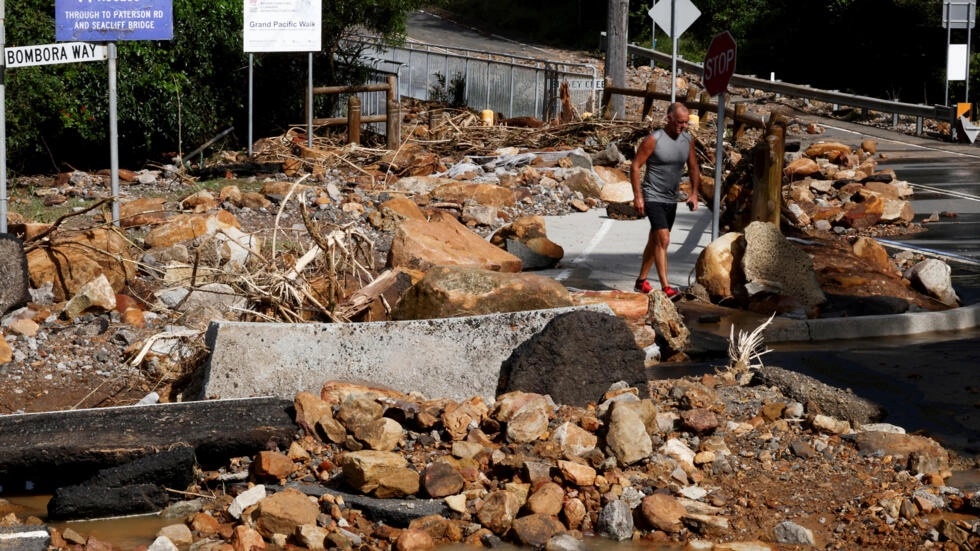 A resident walks past fallen rocks in Wollongong after heavy rain caused flooding in eastern Australia. (AFP) A resident walks past fallen rocks in Wollongong after heavy rain caused flooding in eastern Australia. (AFP)