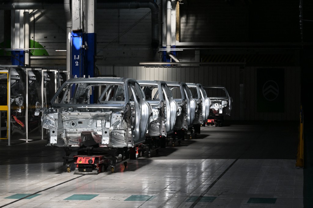 Photo by DAMIEN MEYER / AFP This photograph shows chassis of the new Citroen C5 Aircross on a production line of the Stellantis car maker plant in Chartres-de-Bretagne, near Rennes, western France, on July 3, 2025.
