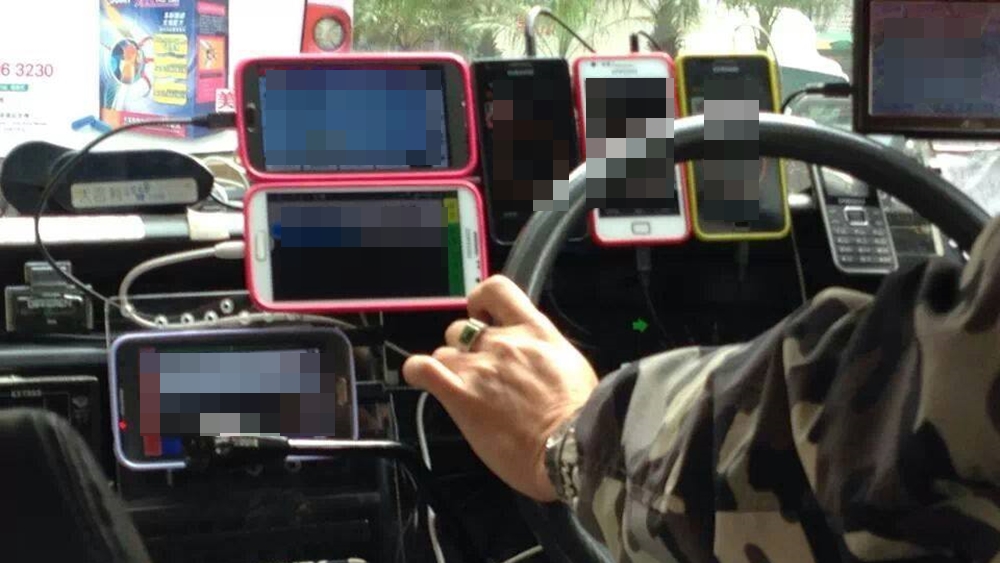 Taxi Driver using Many Phones while Driving, Photo Obtained Online Taxi Driver using Many Phones while Driving, Photo Obtained Online