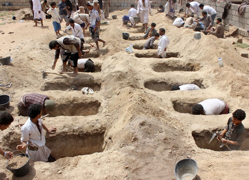 People dig graves for children killed when their bus was hit during a Saudi-led coalition air strike that targeted the Dahyan market the previous day in the Houthi rebels' stronghold province of Saada. (AFP)
