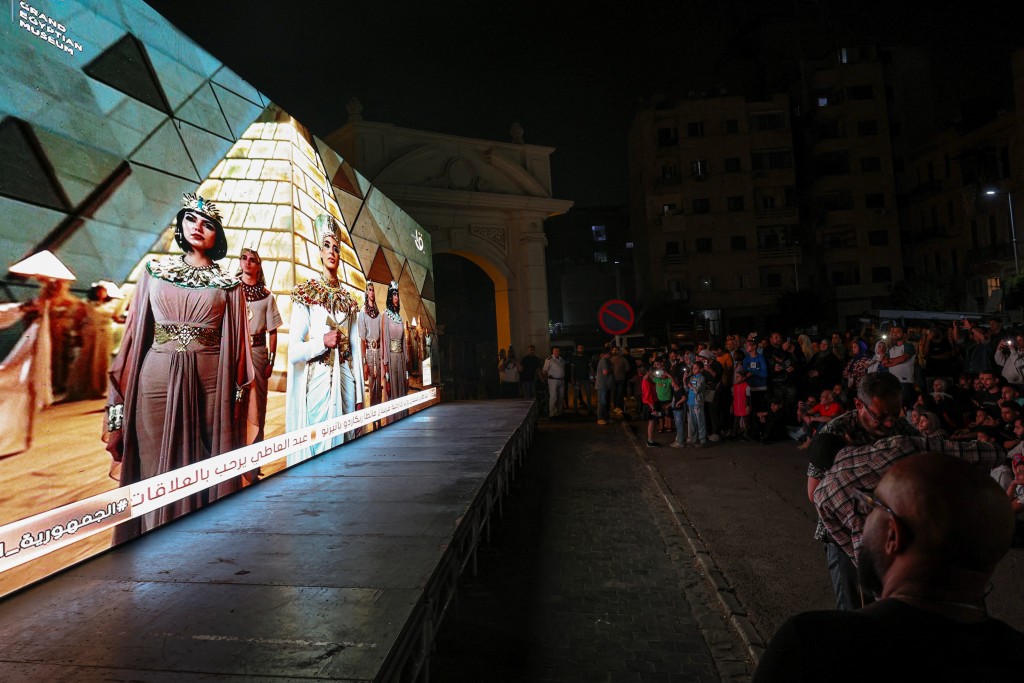 People watch the official opening ceremony of the Grand Egyptian Museum (GEM) on a big screen in the downtown area near Tahrir Square, in front of Abdeen Palace Museum, in Cairo, Egypt, November 1, 2025. (Reuters)