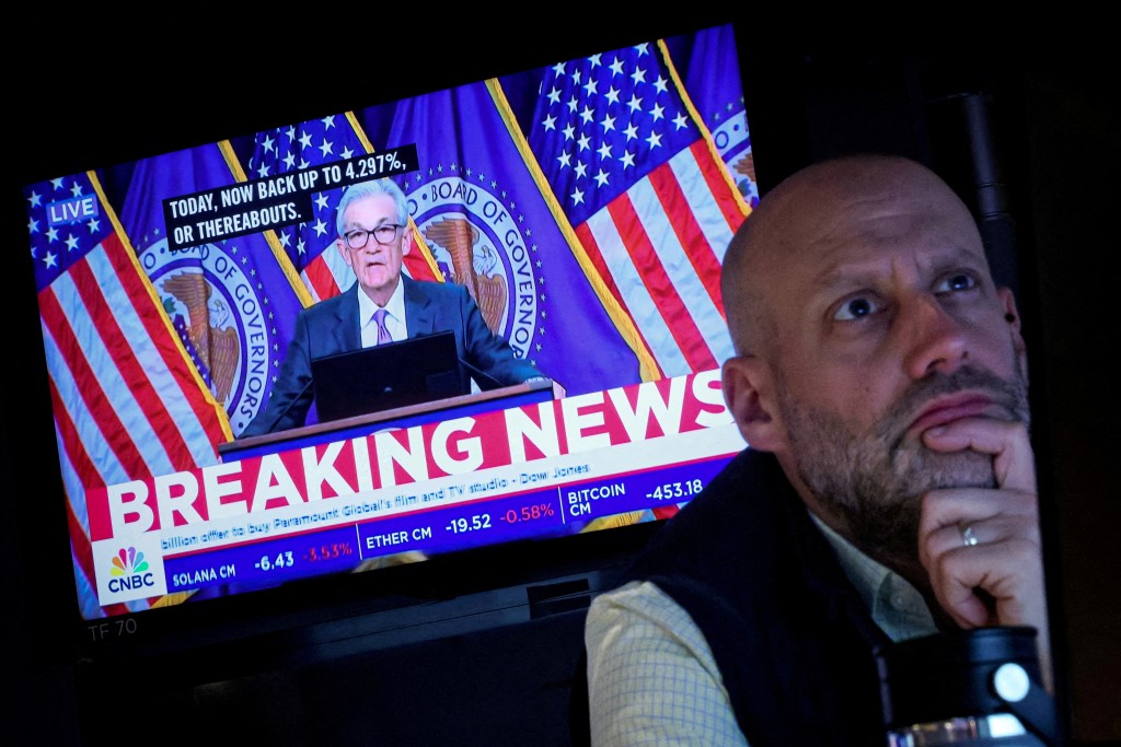 A trader works, as a screen broadcasts a news conference by U.S. Federal Reserve Chair Jerome Powell following the Fed rate announcement, on the floor of the New York Stock Exchange (NYSE) in New York City, U.S., March 20, 2024.  REUTERS/Brendan McDermid/File Photo