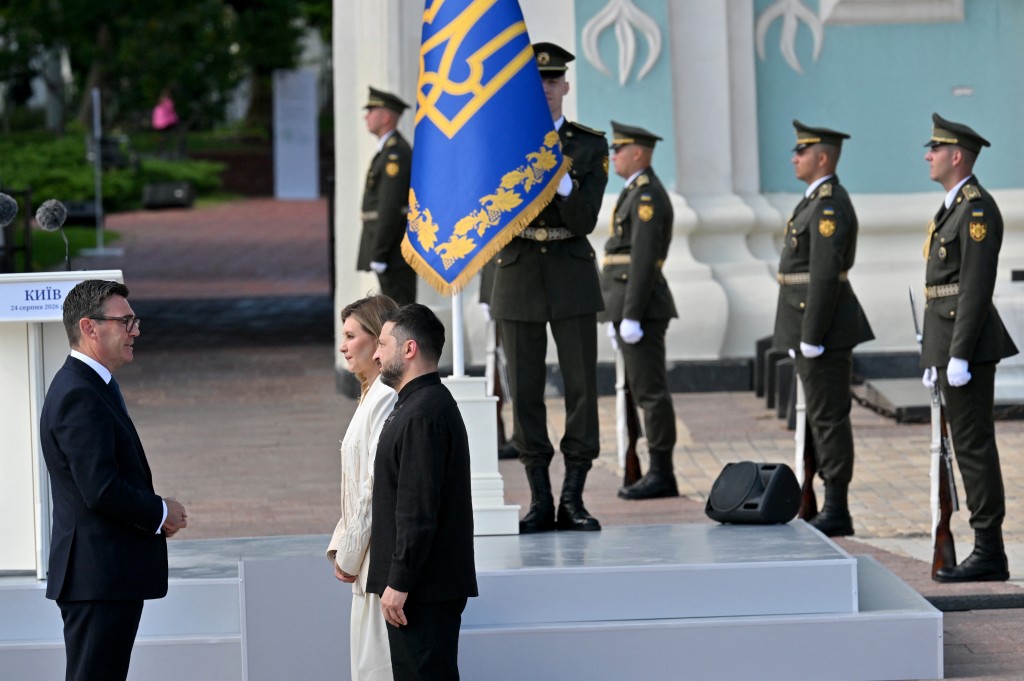Ukraine's President Volodymyr Zelensky (R) and his wife Olena Zelenska (C) welcome Britain's Prime Minister Andy Burnham (L) during a commemorative ceremony marking Ukraine's 35th Independence Day outside St. Sofia cathedral in Kyiv on August 24, 2026.