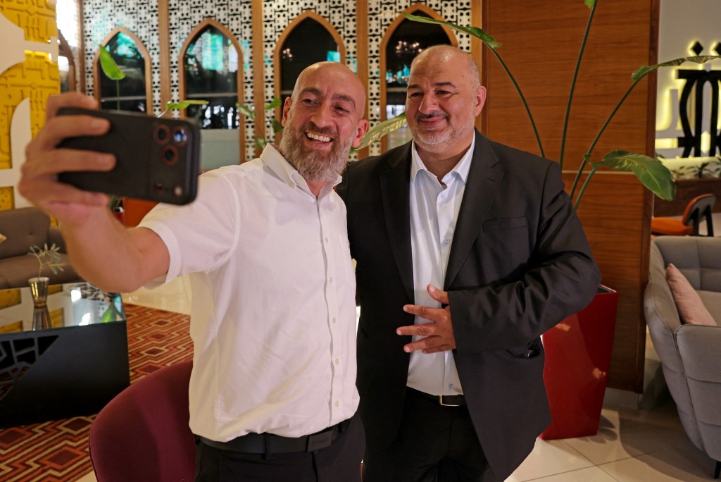 Photo by AHMAD GHARABLI / AFP  Mansour Abbas, head of Israel's conservative Islamic Raam party, takes a selfie with a supporter in Nazareth, in northern Israel, on October 21, 2026.