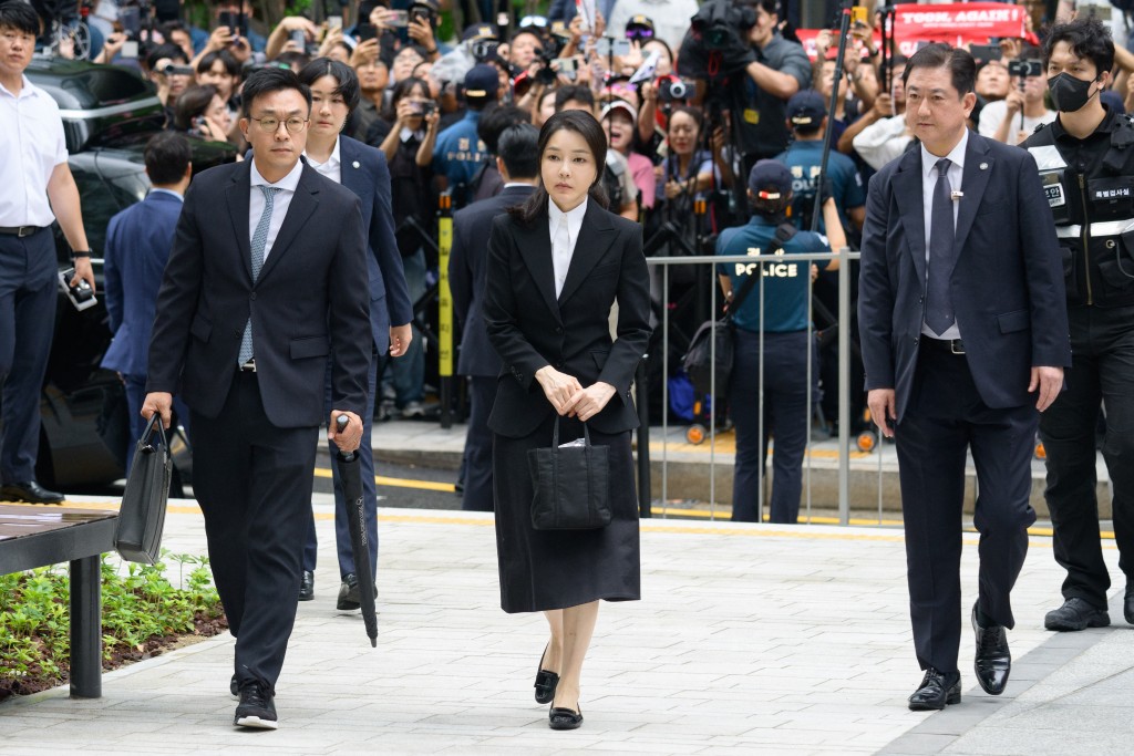 Photo by ANTHONY WALLACE / AFP  South Korea's former first lady Kim Keon Hee (C), wife of impeached former president Yoon Suk Yeol, arrives at the special prosecutor's office in Seoul on August 6, 2025.