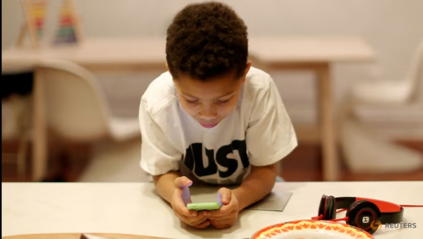 A child plays a game on his phone (Photo: Reuters/Brendan McDermid)