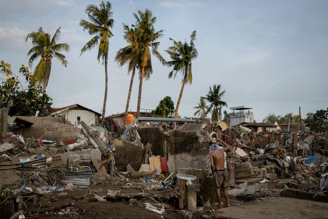 A man takes a bath amid the remains of a community where houses were swept in the floods brought on by Typhoon Kalmaegi in Talisay, Cebu, Philippines, November 6. REUTERS/Eloisa Lopez