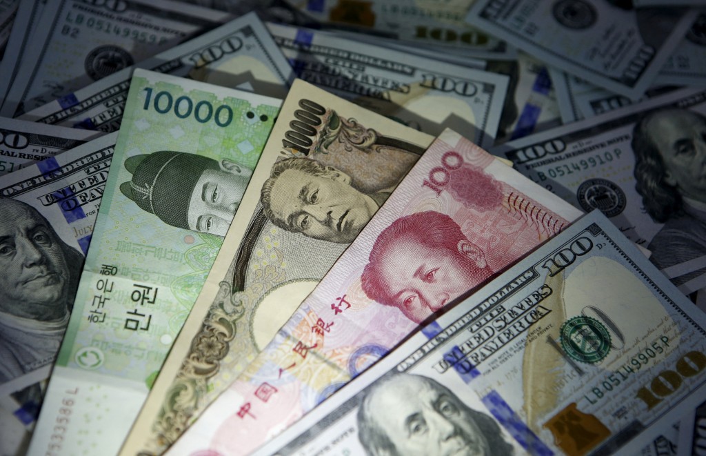 South Korean won, Chinese yuan and Japanese yen notes are seen on U.S. 100 dollar notes in this picture illustration taken in Seoul, South Korea, December 15, 2015. REUTERS