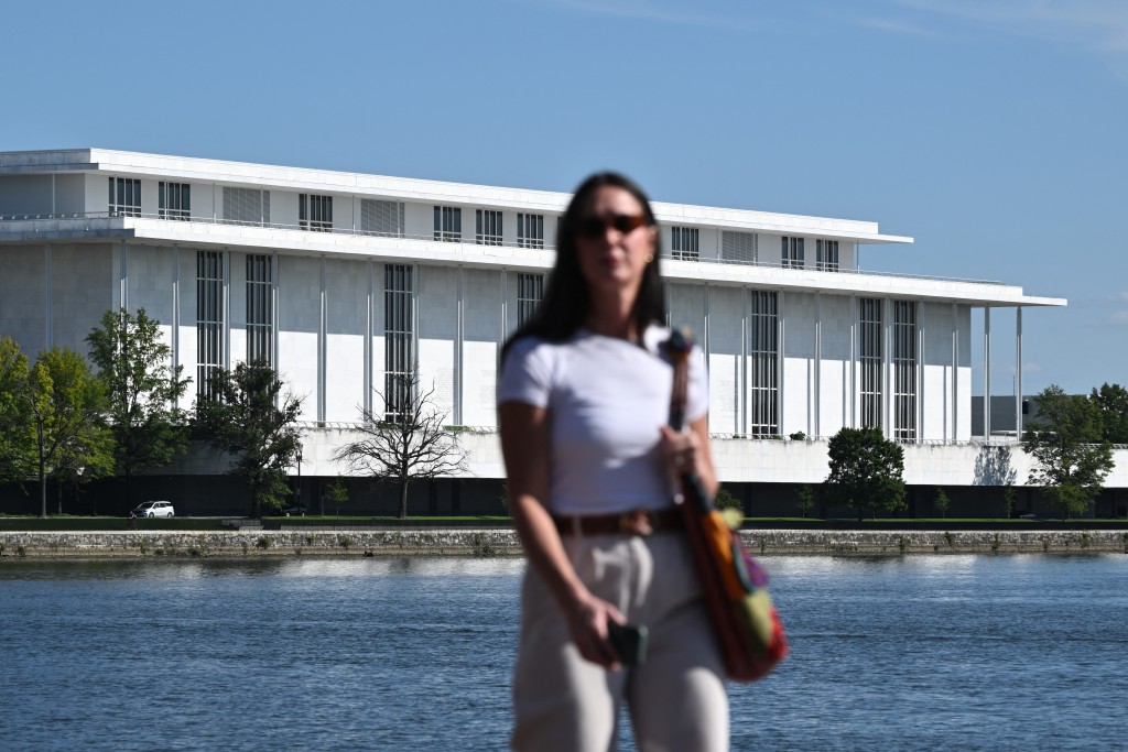 Photo by MANDEL NGAN / AFP A pedestrian walks along the waterfront with the John F. Kennedy Center for the Performing Arts seen in the background, in Washington, DC, on September 15, 2026.