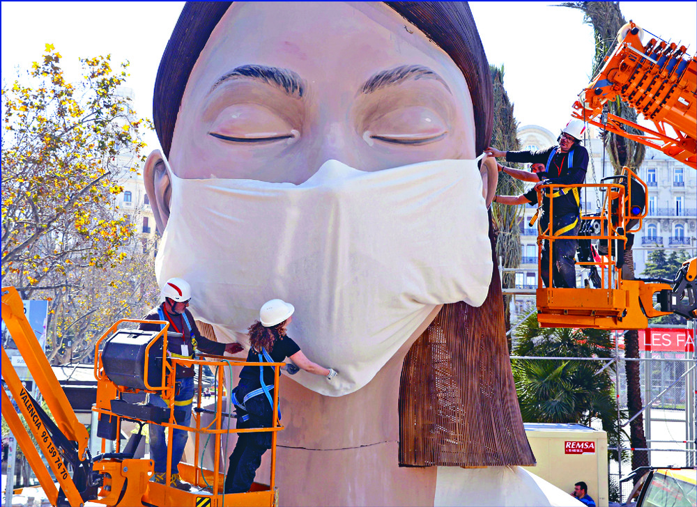 Workers place a mask on a figure made for the Fallas festival in Spain – even though the event originally set to open today has been canceled – as the Luxor temple in Egypt, below, still draws tourists. AP, afp Workers place a mask on a figure made for the Fallas festival in Spain – even though the event originally set to open today has been canceled – as the Luxor temple in Egypt, below, still draws tourists. AP, afp
