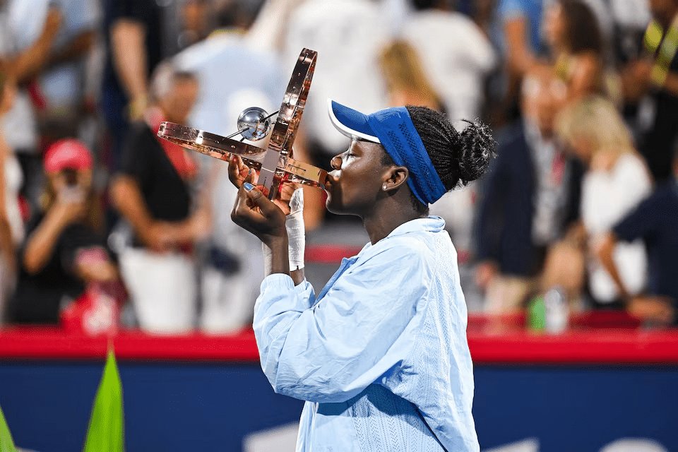 Aug 7, 2025; Montreal, QC, Canada; Victoria Mboko (CAN) tournament winner against Naomi Osaka (JPN) holds her trophy at IGA Stadium. Mandatory Credit: David Kirouac-Imagn Images