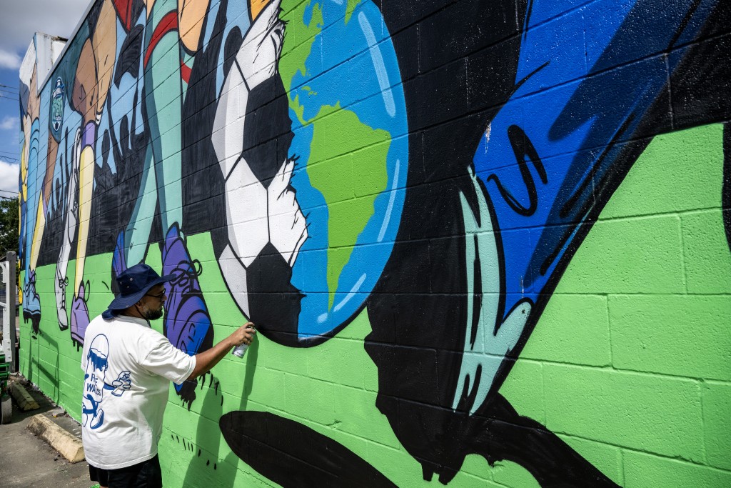 Artist Donkeeboy paints a mural in downtown Houston, near the FIFA Fan Fest in downtown Houston, Texas, on June 10, 2026, ahead of the 2026 FIFA World Cup. (Photo by RONALDO SCHEMIDT / AFP) 