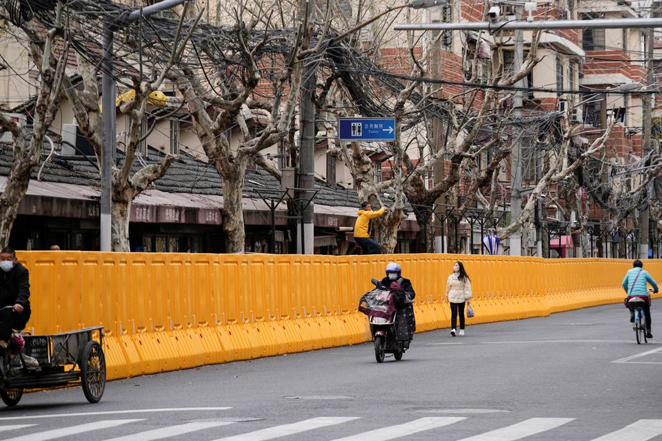 A man climbing a tree looks over barriers, which have been built to separate buildings from a street. (Reuters) A man climbing a tree looks over barriers, which have been built to separate buildings from a street. (Reuters)