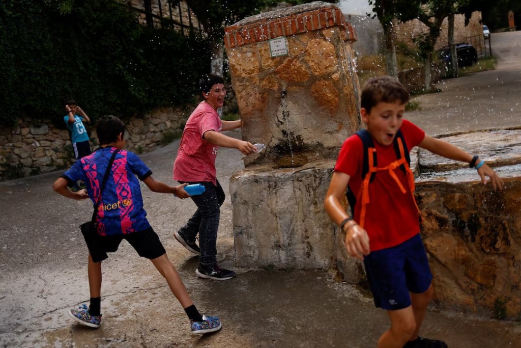 Eloy Moliner, 12, enjoys a water game with children from a neighbouring village where he will attend school in Pitarque, Teruel, Spain. REUTERS/Susana Vera