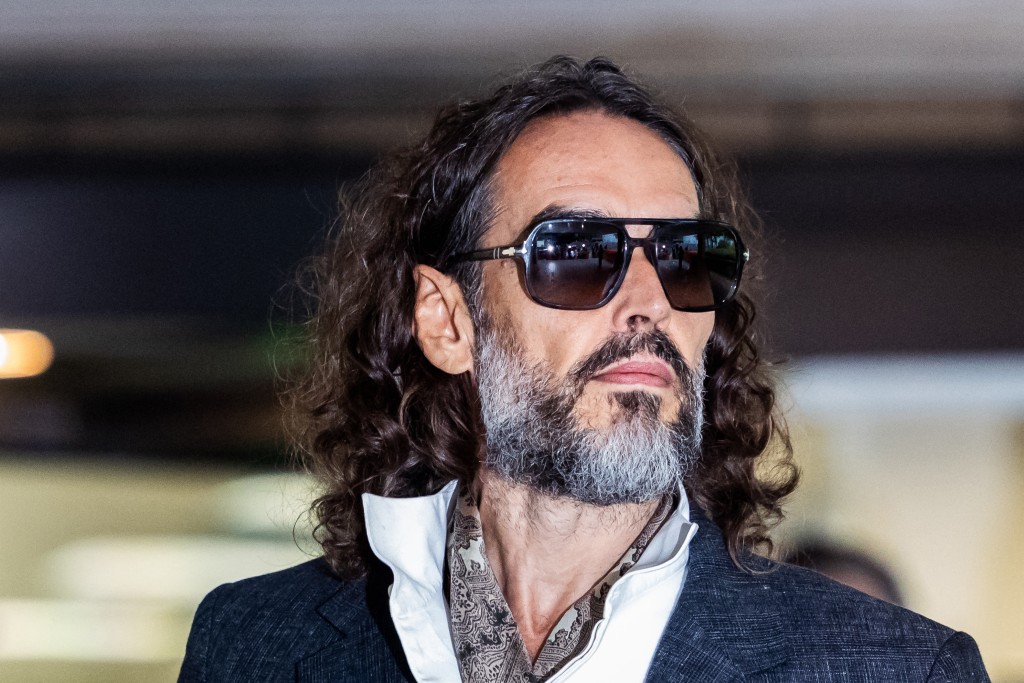 British comedian and actor Russell Brand leaves after jury selection finishes at the start of his trial at Southwark Crown Court in south London on October 12, 2026, after pleading not guilty to three charges of rape, indecent assault, and three counts of sexual assault. (Photo by Brook Mitchell / AFP)
