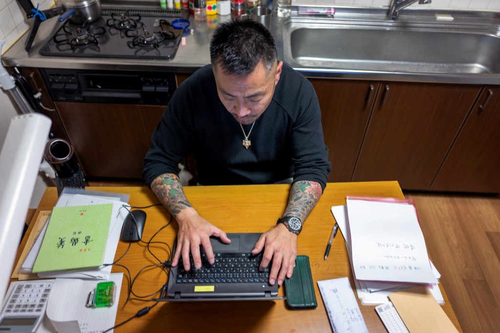 Former gangster Yoshiro Nishino handling paperwork at his group home for ex-offenders in Chiba Prefecture. (AFP)