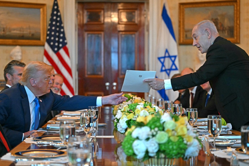 Israeli Prime Minister Benjamin Netanyahu (R) hands over a letter to US President Donald Trump as they meets at the Blue Room of the White House in Washington, DC, on July 7, 2025. (AFP)