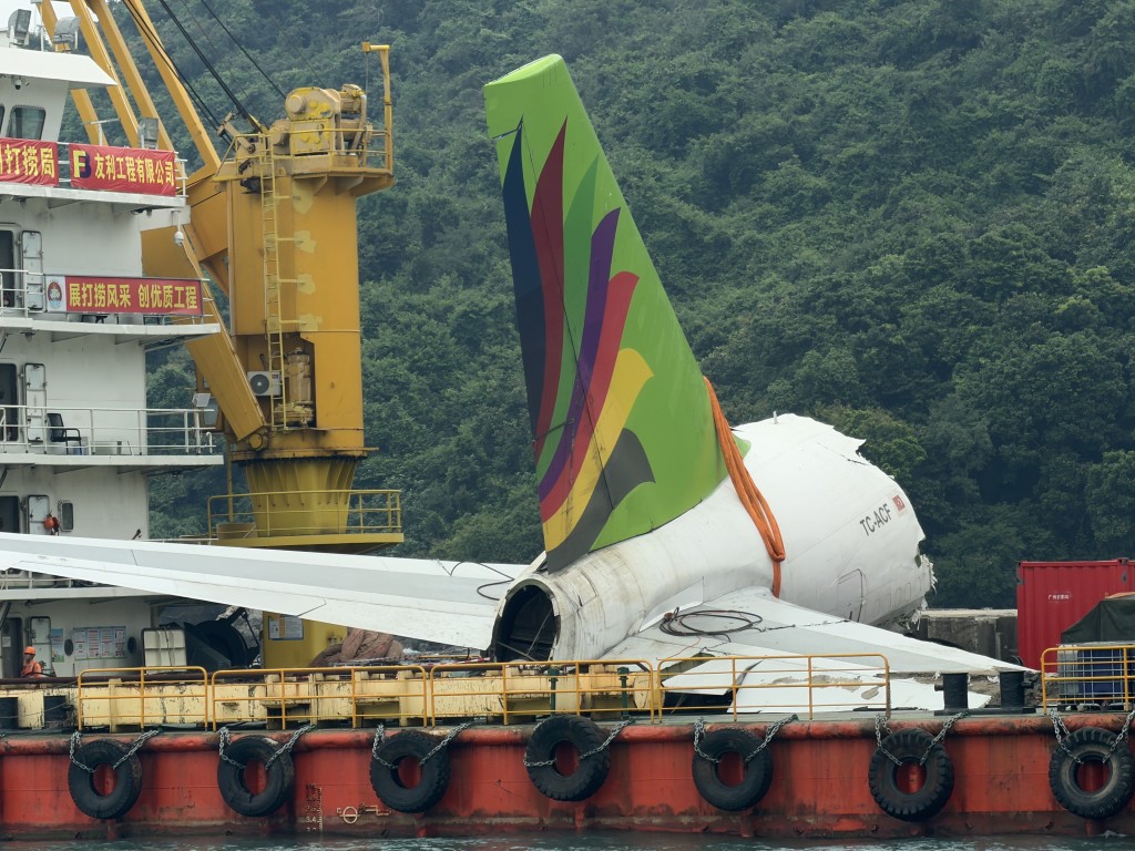 The tail section of the Emirates SkyCargo Boeing 747-400 freighter remains secured on a barge.