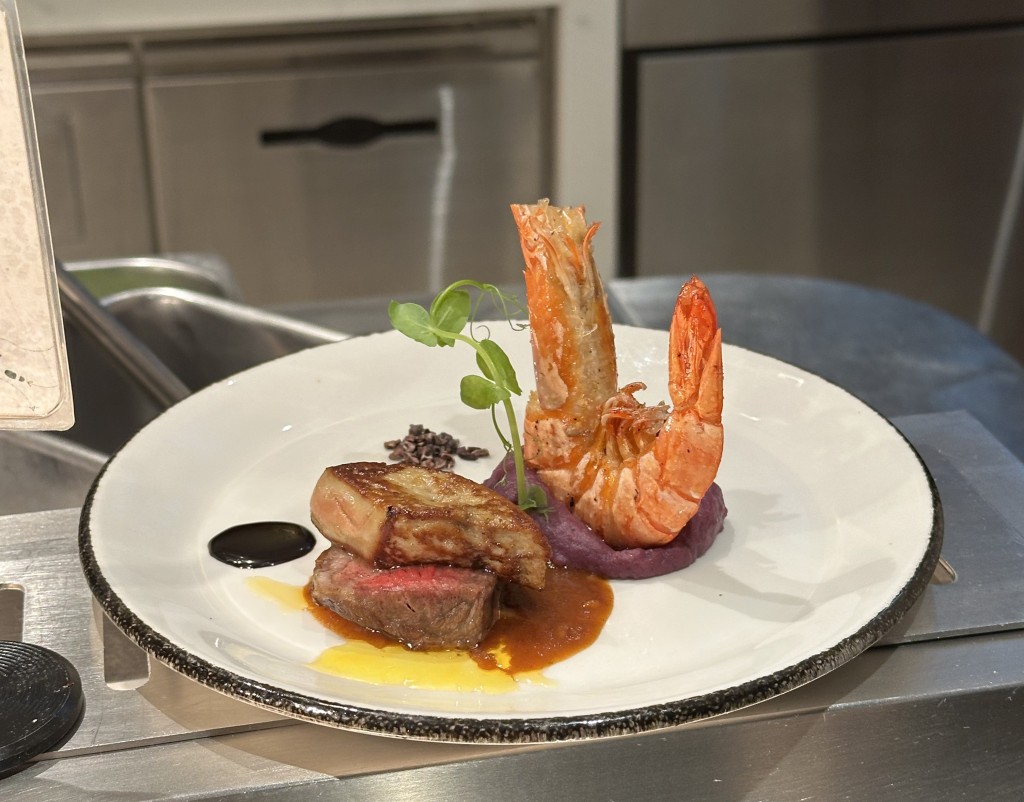 Pan-fried foie gras with chocolate, nuts and berries jam, served along side grilled wagyu and prawns.