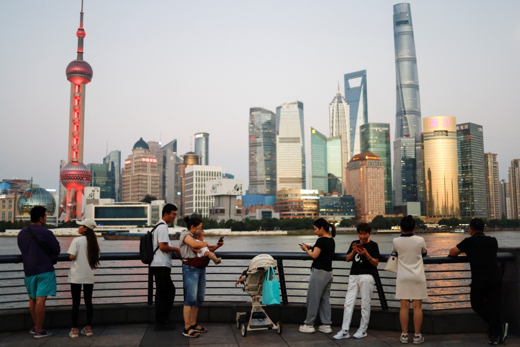 People enjoy themself on the Bund near the financial district of Pudong during the sunset hour, in Shanghai, China September 27, 2024. REUTERS/Tingshu Wang