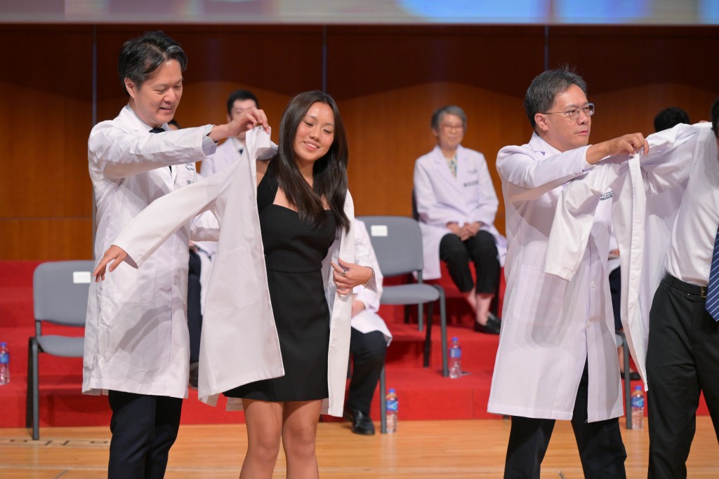 The freshman medical students showed joyful smiles after putting on their white coats.