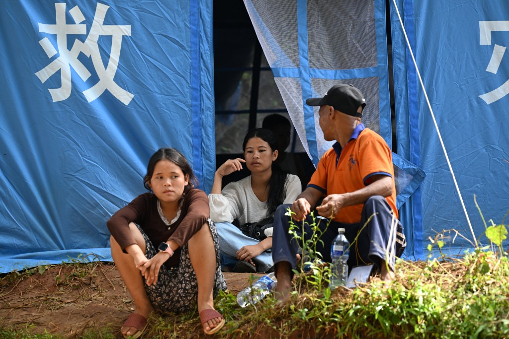 Flood victims sit outside tents at a temporary shelter area in Nepal’s Nuwakot district on September 22, 2026. (Photo by PRAKASH MATHEMA / AFP)