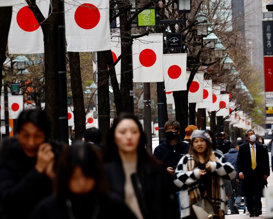 People walk past Japan’s national flags in a shopping district in Tokyo, Japan March 19, 2024. REUTERS/Kim Kyung-Hoon/File Photo