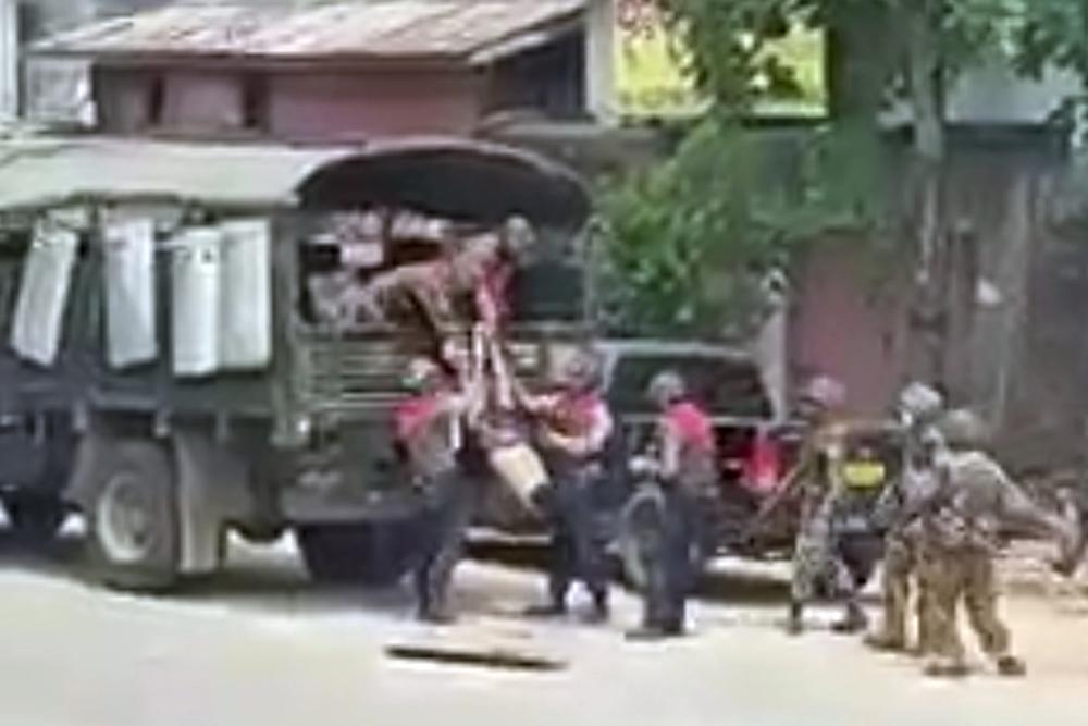 In this March 26, 2021 image from video obtained by The Associated Press, security forces pull the body of an unidentified individual into a military truck in Myeik, Myanmar. Since the military seized control of Myanmar in a takeover on Feb. 1, more than an estimated 800 people have been killed _ three times the official tally _ according to the local watchdog group Assistance Association for Political Prisoners.