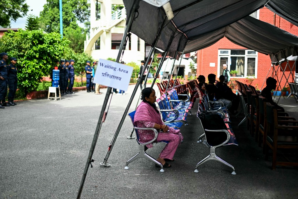 Photo by MANAN VATSYAYANA / AFP Family members wait to register their information with police personnel to give blood samples for DNA testing to help identify their missing relatives after flash floods, at the Nepal Police Hospital in Kathmandu on September 3, 2026.