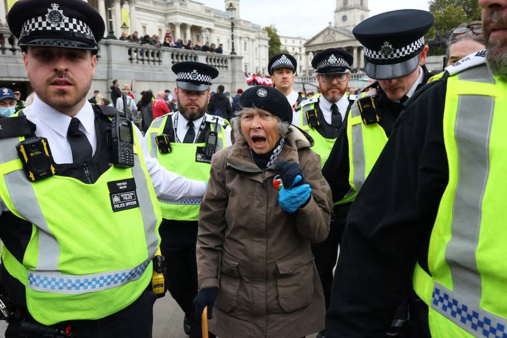 Police officers detain a protester, during a mass demonstration organised by Defend our Juries, against the British government's ban on Palestine Action, in London, Britain, October 4, 2025. REUTERS/Toby Melville 