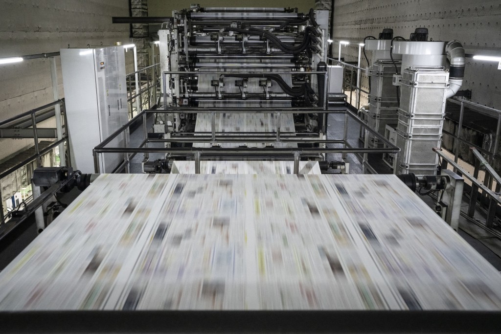 Photo by YUICHI YAMAZAKI / AFP  This picture taken on March 19, 2026 shows newsprint passing through machinery at the Kyoto Shimbun factory in Kumiyama, Kyoto prefecture.