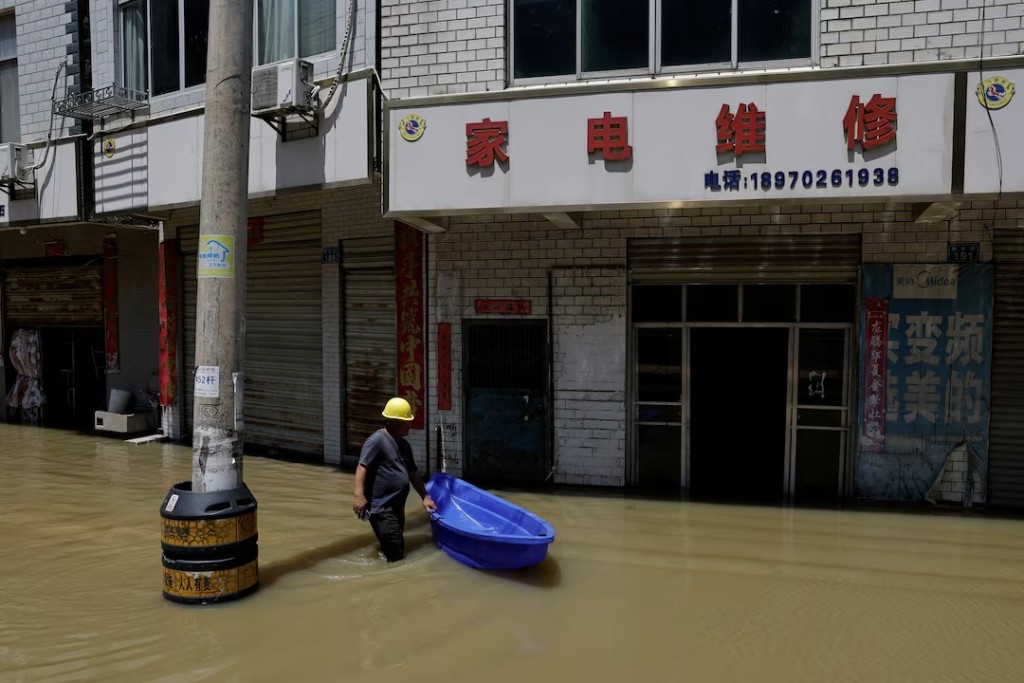  A resident wades through floodwaters after heavy rainfall and waters from the upstream Yangtze River flooded a town in Hukou county of Jiujiang, Jiangxi province, China July 5, 2024. REUTERS/Tingshu Wang/File Photo