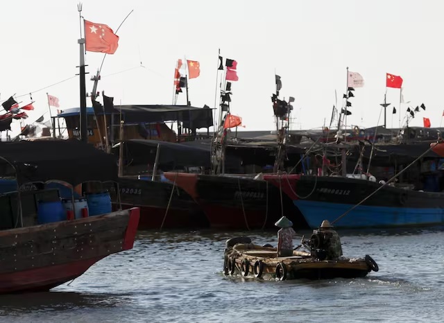 A dinghy ferries people to fishing boats at a port in the city of Dongfang on the western side of China's palm-fringed island province of Hainan, June 18, 2014.REUTERS/John Ruwitch