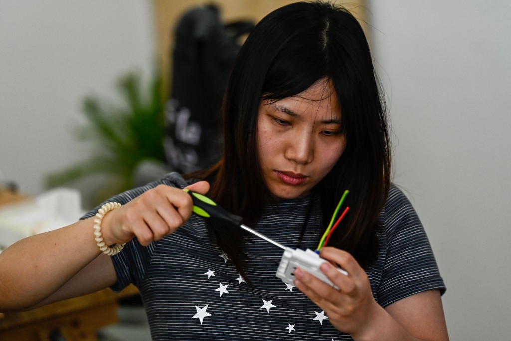 Photo by PEDRO PARDO / AFP  This picture taken on June 28, 2026 shows a woman practicing during an electricity course at the Mulan Build workshop in Hangzhou, in eastern China's Zhejiang province.
