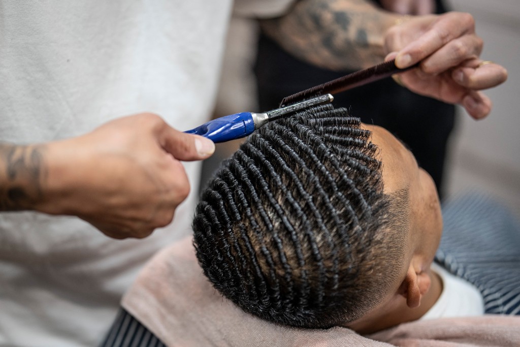 Photo by YUICHI YAMAZAKI / AFP  This photo taken on August 27, 2026 shows Tekisasu, an active yakuza gangster allied to a major clan, having his hair permed at a barbershop in Tokyo.
