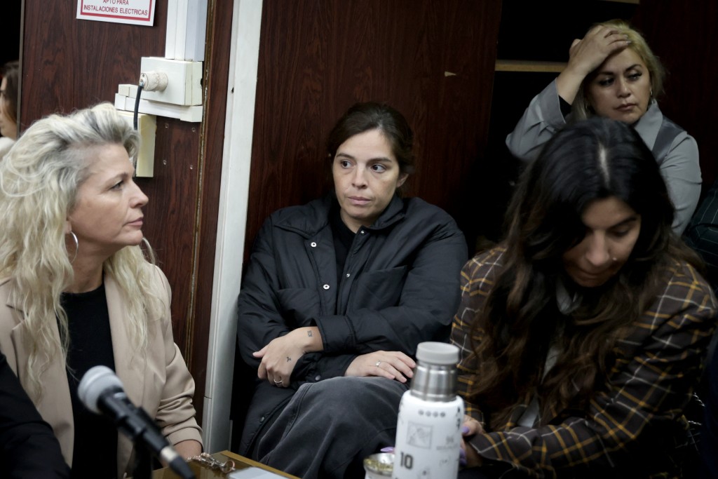 Dalma Maradona (C) and Giannina Maradona (R), daughters of late Argentine football legend Diego Maradona, attend a court hearing in the trial over Maradona's death alongside Veronica Ojeda (background), former partner of Maradona and mother of Diego Fernando Maradona, in San Isidro, Buenos Aires province, Argentina, on October 8, 2026. (Photo by STRINGER / AFP)