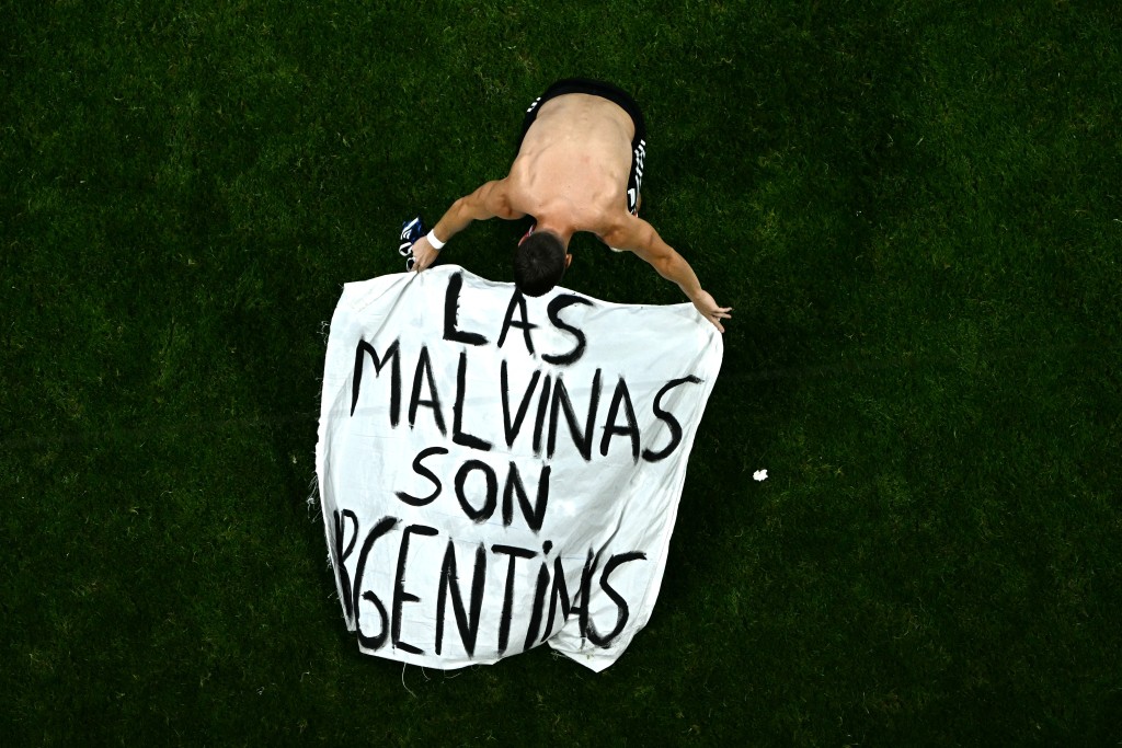 Argentina's midfielder #11 Giovani Lo Celso adjusts a banner reading "The Malvinas (Falkland Islands) belong to Argentina," after winning the 2026 World Cup football tournament semi-final match between England and Argentina at the Atlanta Stadium in Atlanta on July 15, 2026. (Photo by Jewel SAMAD / AFP)