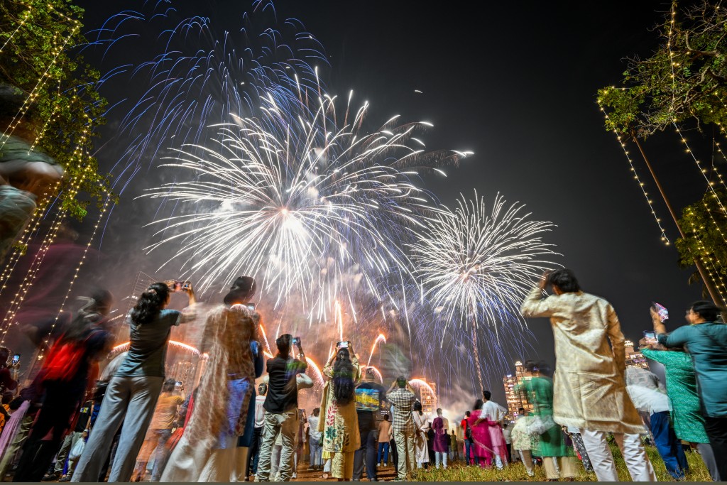 Photo by PUNIT PARANJPE / AFP Local residents watch fireworks light up the sky as part of Diwali celebrations, the Hindu festival of lights, in Mumbai on October 22, 2025.