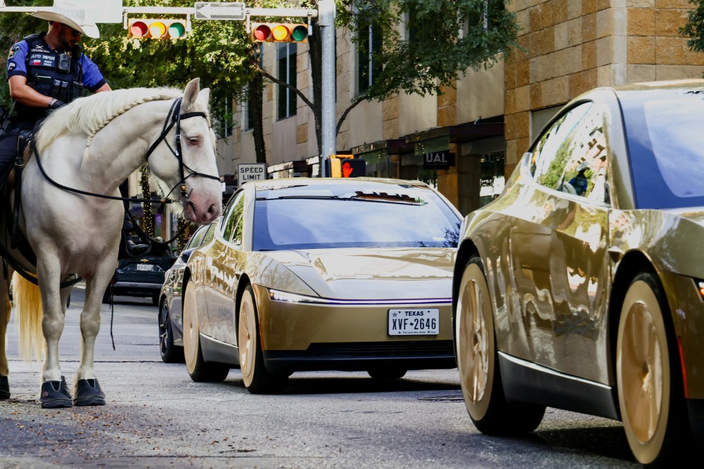 Mounted police patrols as gold-colored Tesla Cybercabs arrive for an event in downtown Austin, Texas, U.S., September 3, 2026.  REUTERS/Kaylee Greenle