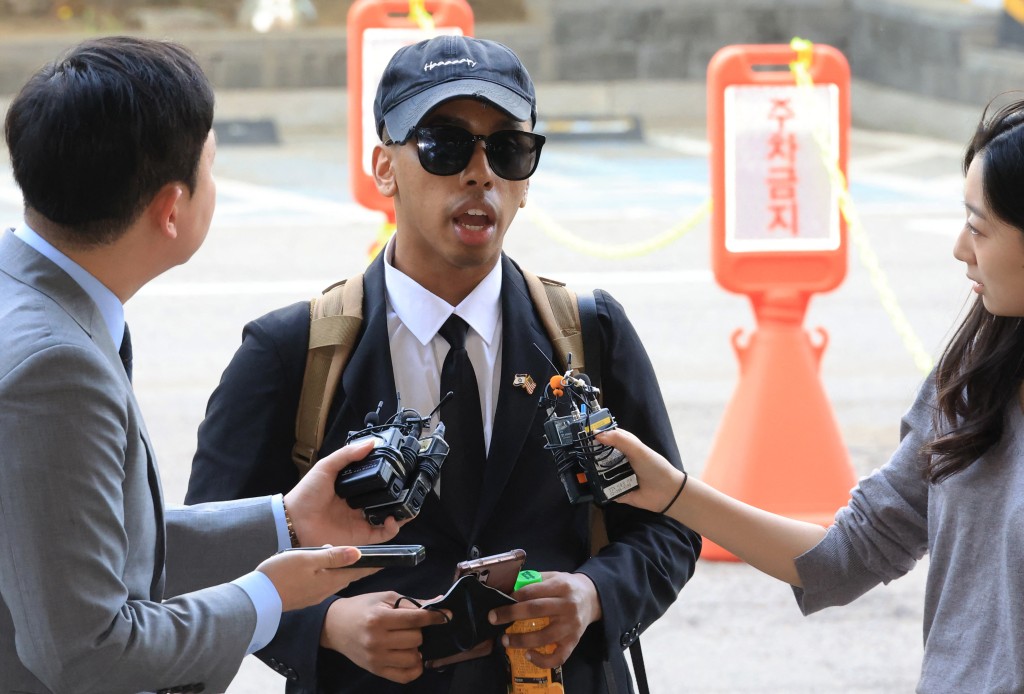 Photo by - / YONHAP / AFP  US YouTuber Johnny Somali speaks to reporters as he arrives at a court to attend his trial over charges including obstruction of business and violations of minor public order laws, at the Seoul Western District Court in Seoul on April 15, 2026.