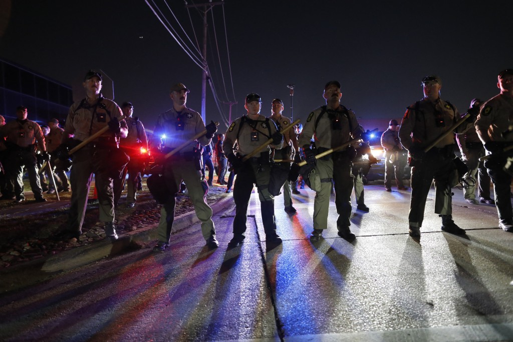 Illinois State Police stand guard while monitoring protesters gathering near an Immigration and Customs Enforcement (ICE) facility in Broadview, Illinois, on October 4, 2025. US President Donald Trump, who campaigned on a pledge to deport large numbers of migrants, has encouraged authorities to be more aggressive as he seeks to hit his widely reported target of one million deportations annually. (Photo by OCTAVIO JONES / AFP)