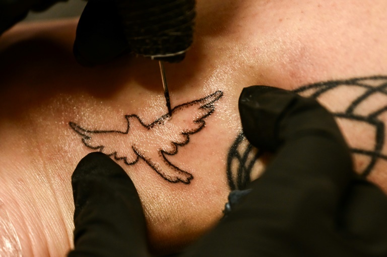 Tattoo artist Kat Dukes inks a hand poked tattoo of a dove on Scout Frank using ink mixed with the ashes of Frank’s cremated mother in Oceanside, California on October 6, 2023 Patrick T. Fallon Tattoo artist Kat Dukes inks a hand poked tattoo of a dove on Scout Frank using ink mixed with the ashes of Frank’s cremated mother in Oceanside, California on October 6, 2023 Patrick T. Fallon