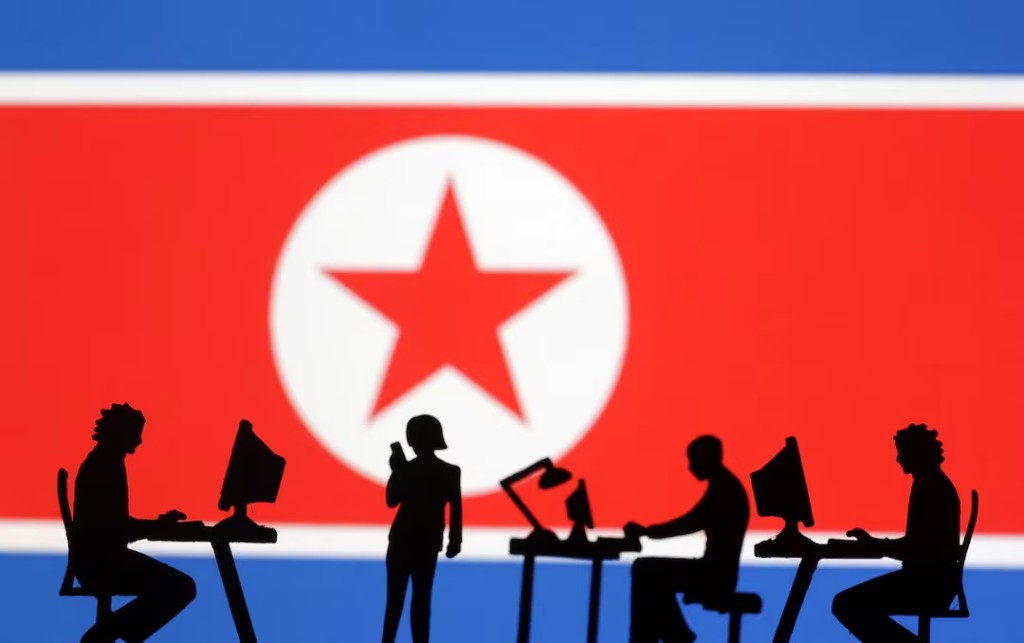 Miniatures of people with computers are seen in front of North Korea flag in this illustration taken July 19, 2023. REUTERS/Dado Ruvic/Illustration