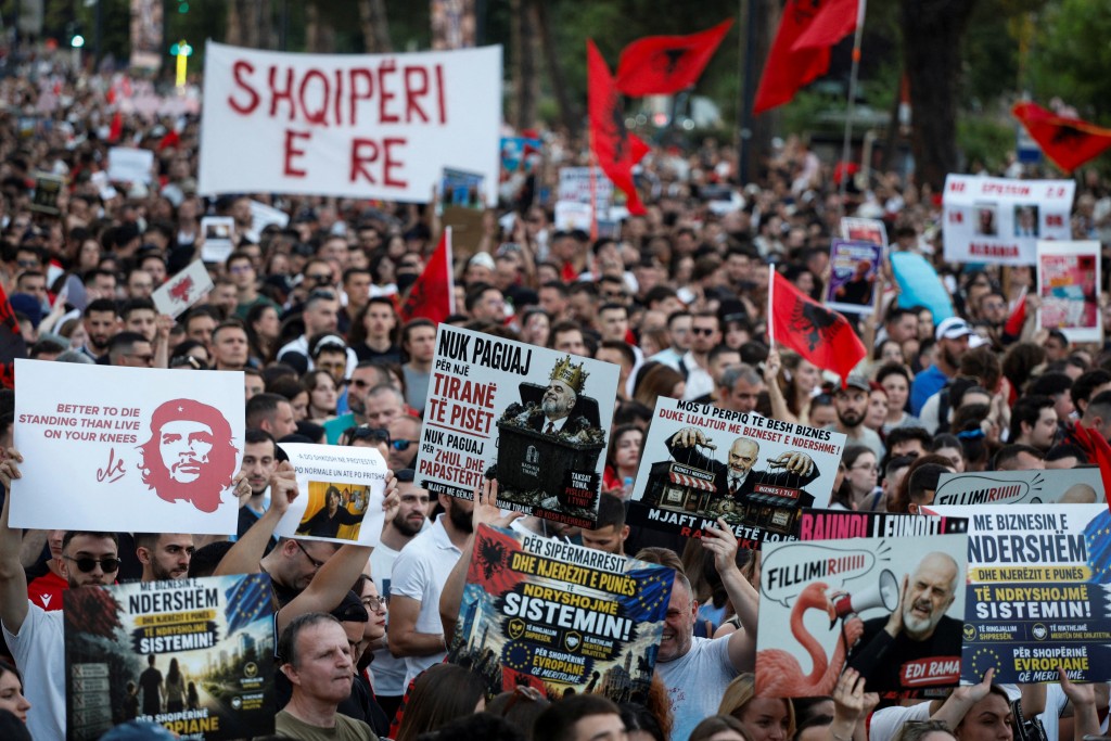 Photo by ADNAN BECI / AFP. Protestors hold national flags as they gather in front of Albania's Prime Minister's Office, in Tirana, on June 8, 2026 during a demonstration against the construction of a luxury resort near a protected natural area, against the construction of a luxury resort near a protected natural area in Zvernec near Vlore.