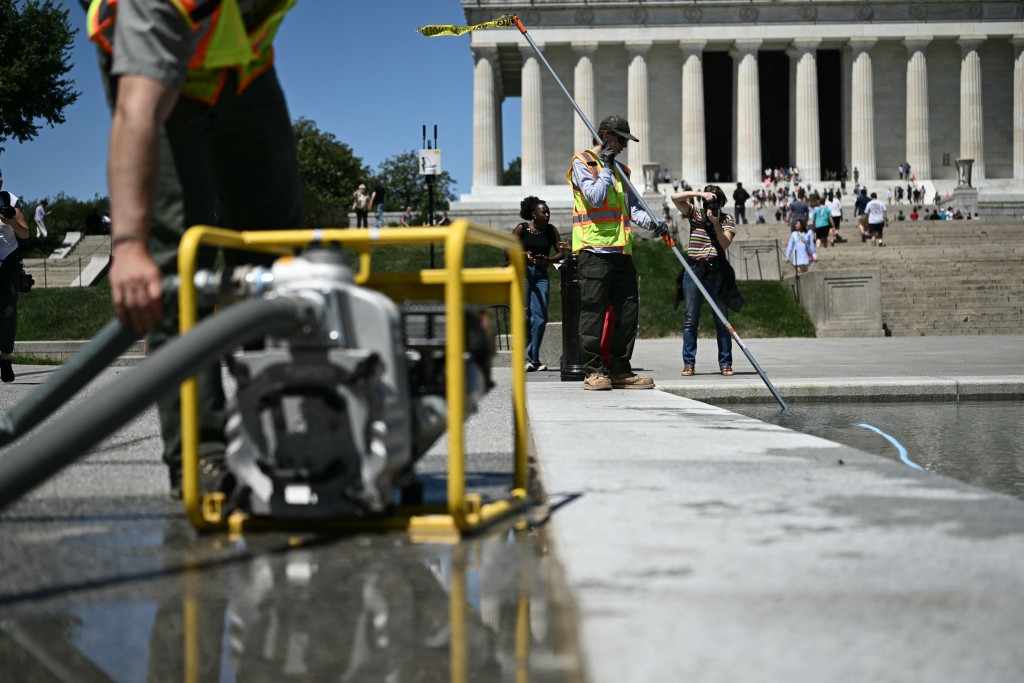 Photo by BRENDAN SMIALOWSKI / AFP  Members of the National Park Service using a water pump remove algae from the Lincoln Memorial Reflecting Pool following the completion of recent renovations in Washington, DC, on June 16, 2026.
