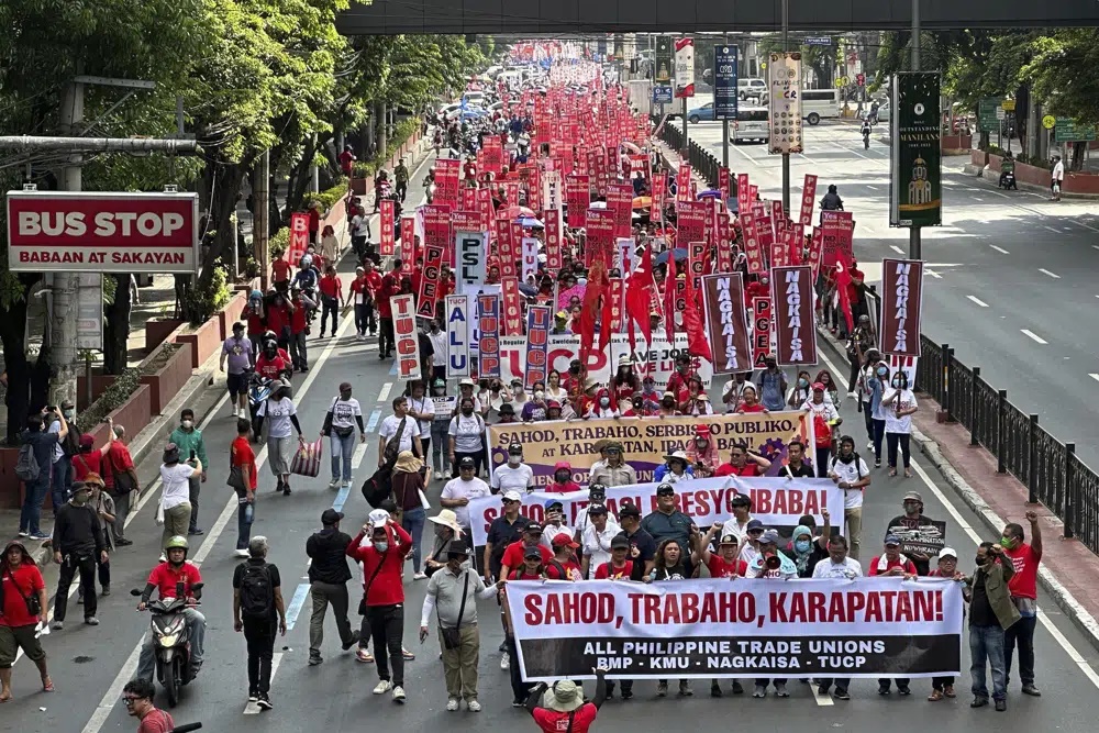 Filipino protesters hold slogans as they march along a road to mark International Labor Day in Manila, Philippines on Monday May 1, 2023. Thousands of Filipino workers marched in the streets of Manila on Monday, reiterating their calls to the government to increase the basic minimum wage, protect jobs in the country. (AP)