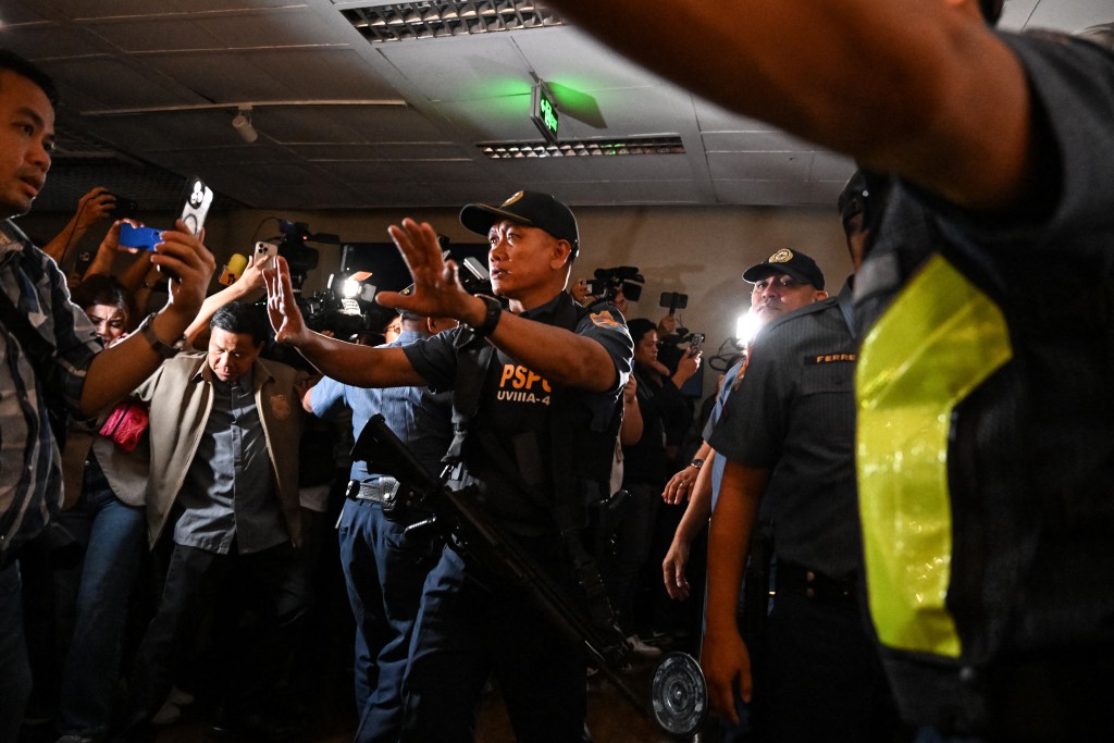 Police personnel arrive as people react to the gunshots heard inside the Senate of the Philippines in Pasay, Metro Manila on May 13, 2026. © JAM STA ROSA / AFP